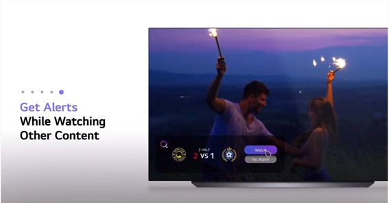 An LG TV displaying a Sports Alert notification which shows the live scoreline while a video of a couple dancing with fireworks plays on its screen.