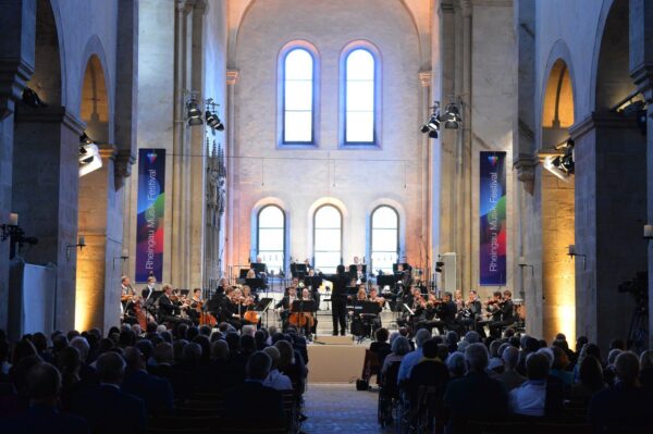 A small orchestra playing in front of a full audience inside the Eberbach Monastery during the Rheingau Musik Festival.