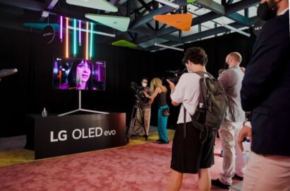 Visitors admiring and taking pictures of the artwork being displayed on LG OLED evo TV