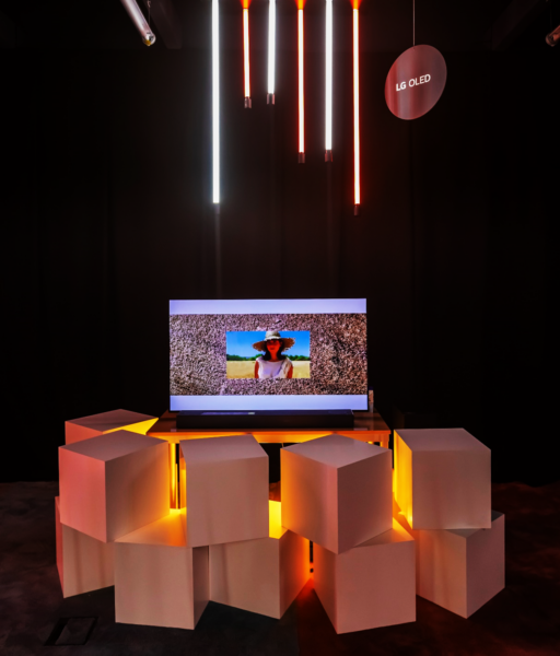 “Terraferma” by María Leyba and Mikaela Martínez displayed on LG OLED TV with decorative cubes and neon lighting surrounding the exhibit