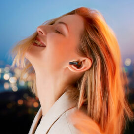 A stylish woman experiencing the immersive sound of LG’s Charcoal Black TONE Free FP8 while outdoors