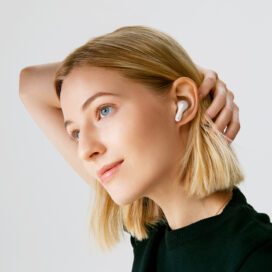 A woman pulling her hair back to demonstrate Pearl White TONE Free FP8’s comfortable fit
