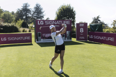 Professional golfer Ko Jin-young tees off in front of LG SIGNATURE signage.