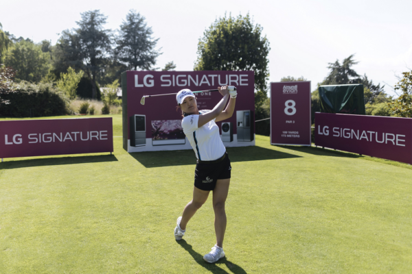 Professional golfer Ko Jin-young tees off in front of LG SIGNATURE signage. 