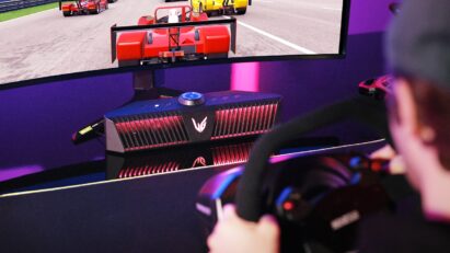 A gamer playing a game on an LG UltraGear gaming monitor connected to an LG UltraGear Gaming Speaker (model GP9).