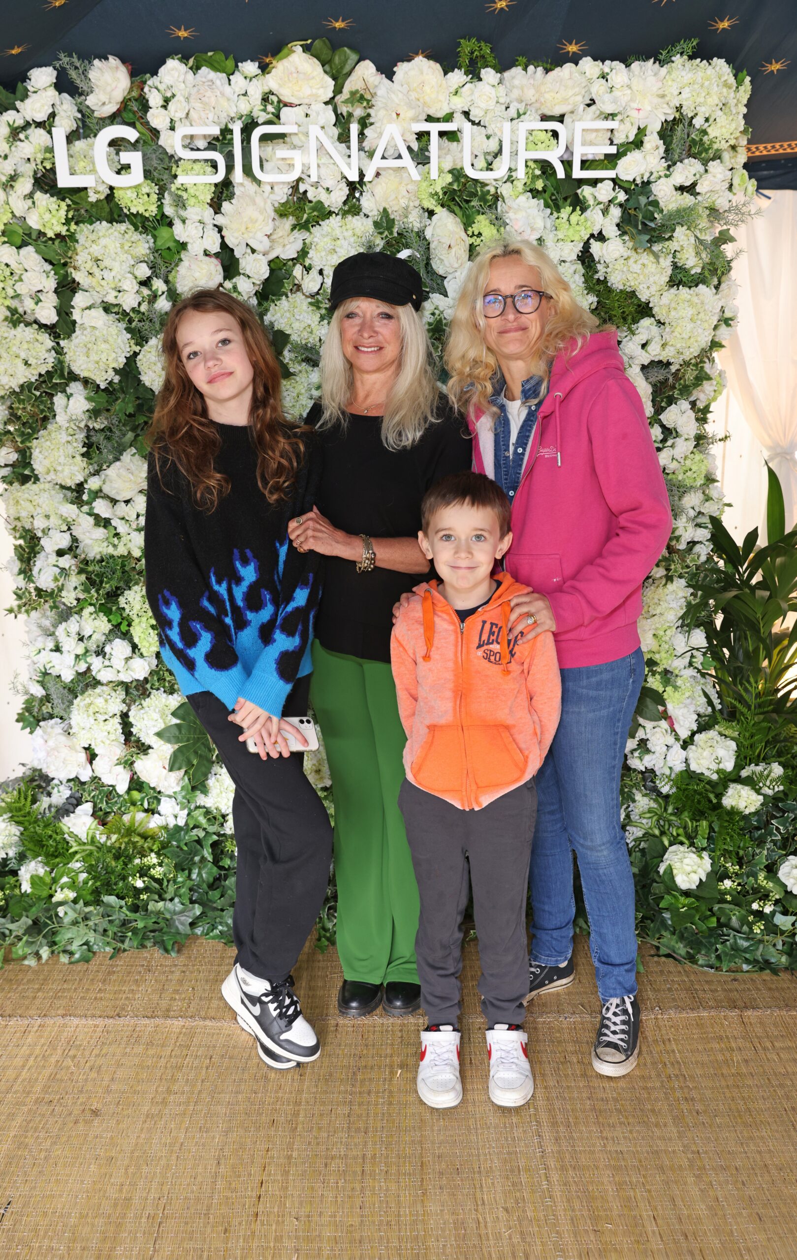 Jo Wood poses with her daughter and grandchildren in front of the LG SIGNATURE display.