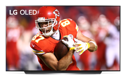 Image of Kansas City Chiefs’ Travis Kelce shielding the football during a game displayed on LG OLED TV.