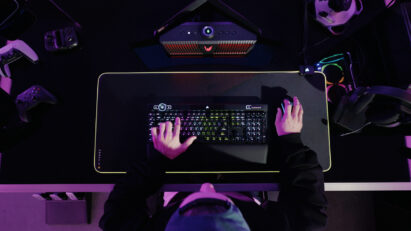 A gamer playing a game with an LG UltraGear Gaming Speaker (model GP9) set up