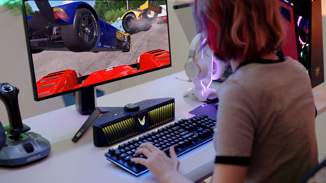 A gamer playing a game on an LG UltraGear gaming monitor with an LG UltraGear Gaming Speaker (model GP9) set up