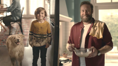 A dad can't help but smile at his son and dog who are both covered in mud.