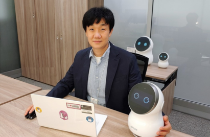 A photo of Dr. Baek Seung-min posing with LG CLOi robot