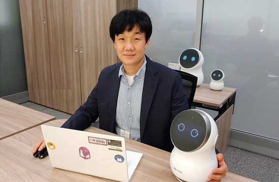 A photo of Dr. Baek Seung-min posing with LG CLOi robot 