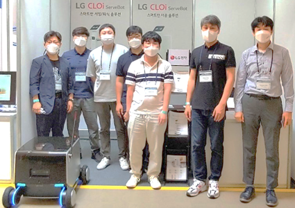 LG's robotics team posing with the indoor-outdoor delivery robot they recently developed.