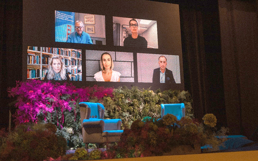 Five notable people being streamed live on the BFE Summit’s main stage screen. 