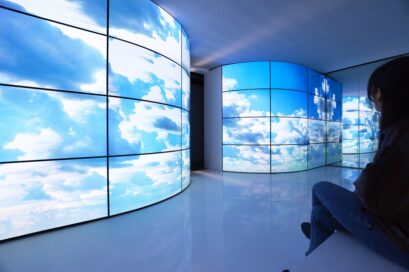A visitor marveling at the realistic blue sky shown by a curved-wall art installation made up of LG OLED displays