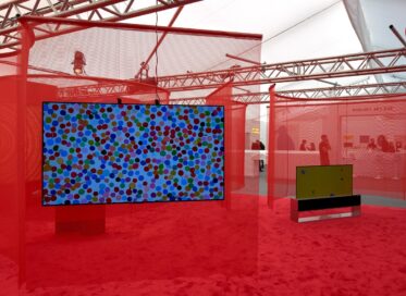 LG OLED TVs displaying colorful artwork in an art exhibition with a red theme