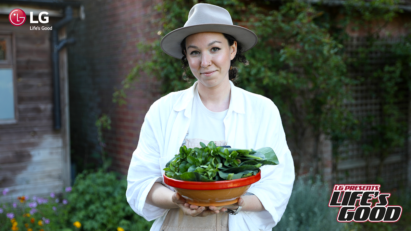 Immy posing with her homegrown vegetables which represent one of her ways of living sustainably.