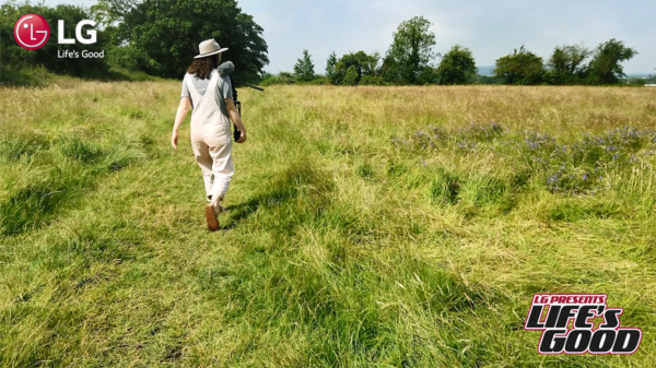 A screenshot from LG's Life's Good video showing Immy walking through a green field. 