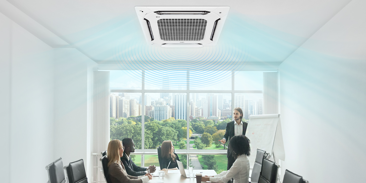 Workers having a team meeting in a room equipped with LG’s 4-Way DUAL Vane Cassette.