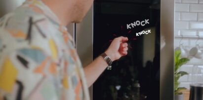 A man knocking twice on the LG InstaView Door-in-Door refrigerator’s window to light it up.