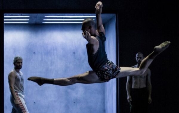 A professional dancer pulling off a grand jeté during a ballet performance.