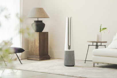 A front view of LG PuriCare AeroTower Beige air purifying fan in a bright room next to traditional interior decoration.