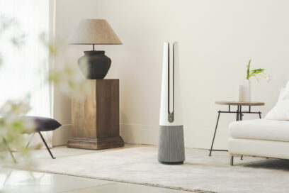 A front view of LG PuriCare AeroTower Beige air purifying fan in a bright room next to traditional interior decoration.