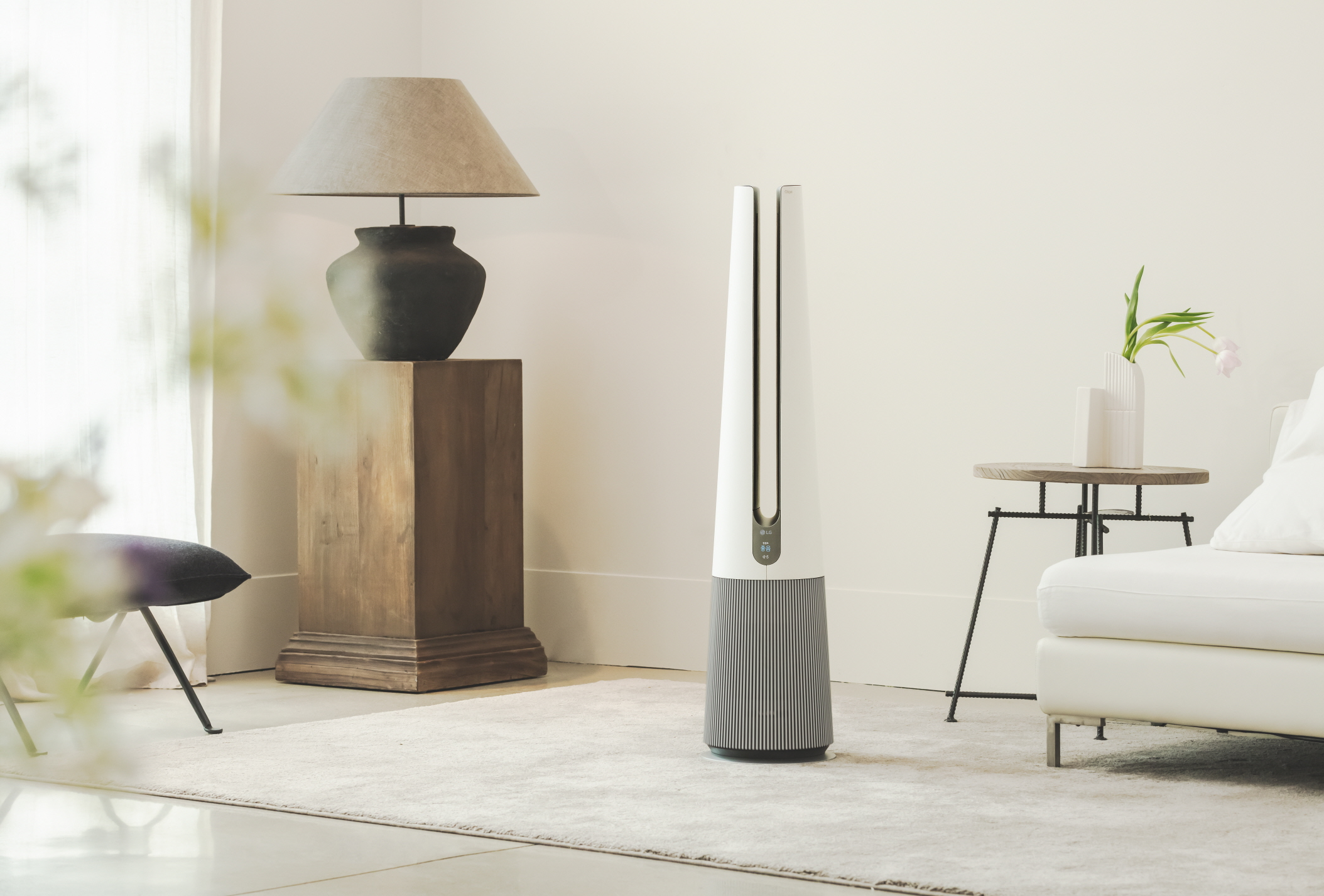A front view of LG PuriCare AeroTower Beige air purifying fan in a bright room next to traditional interior decoration.