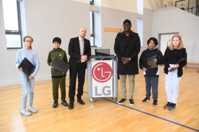 English football legend Emile Heskey posing with children taking part in the LG Laptop Library program.