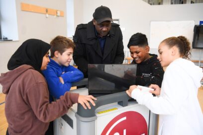 Students taking a closer look at LG gram with former English professional football player Emile Heskey.