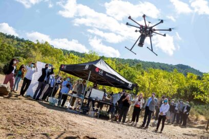 A drone flying around to gather information about the surrounding area that will help minimize the environmental impact and aid germination of the land.