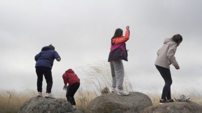 Children throwing homemade seed balls into donated lands to plant trees in the area.