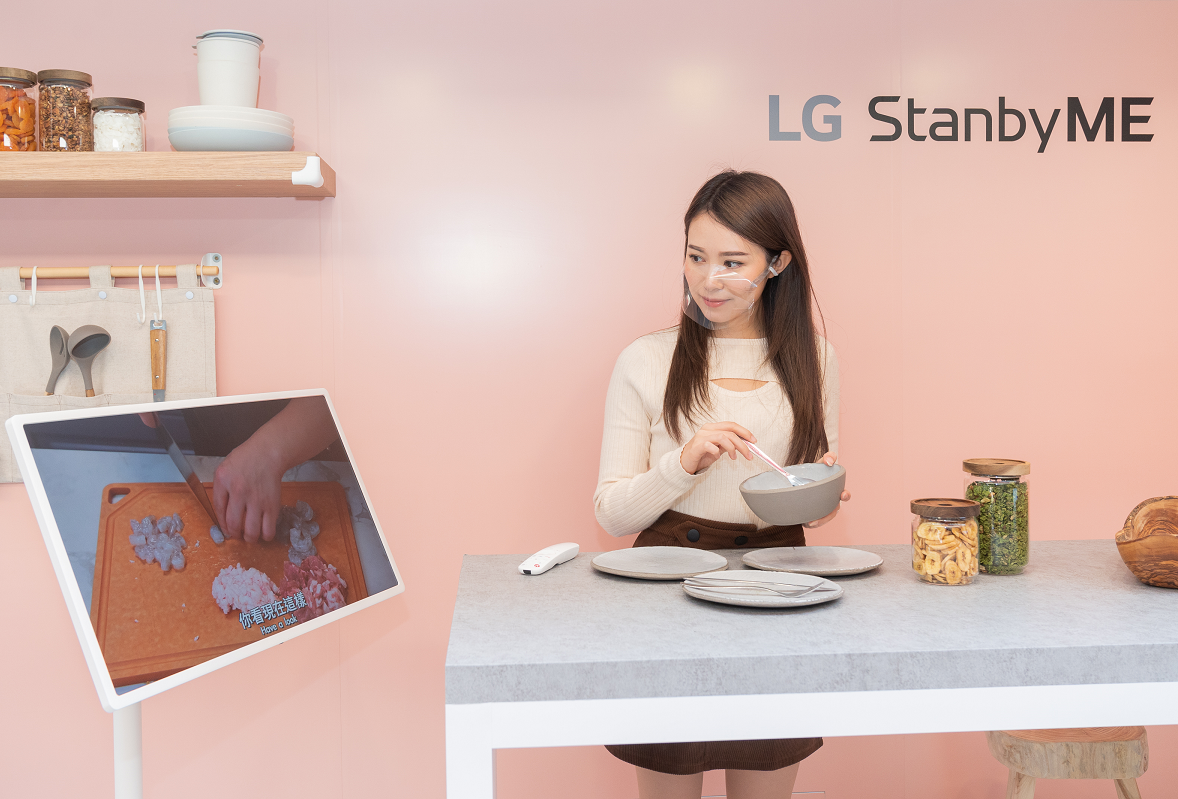 The Hong Kong launch event’s Kitchen Zone with a woman preparing a meal with the help of a cooking video displayed on LG StanbyME.