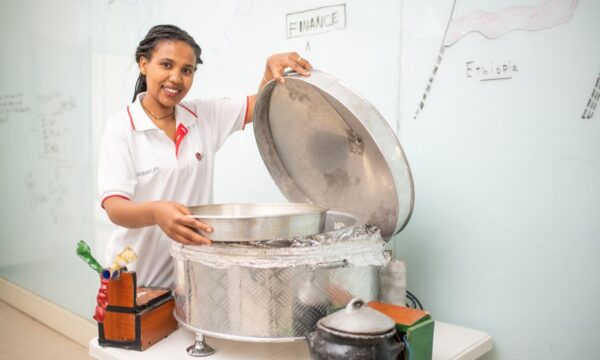 A student posing with a steam bread baker developed based on the support of the Incubation Center by LG and KOICA.