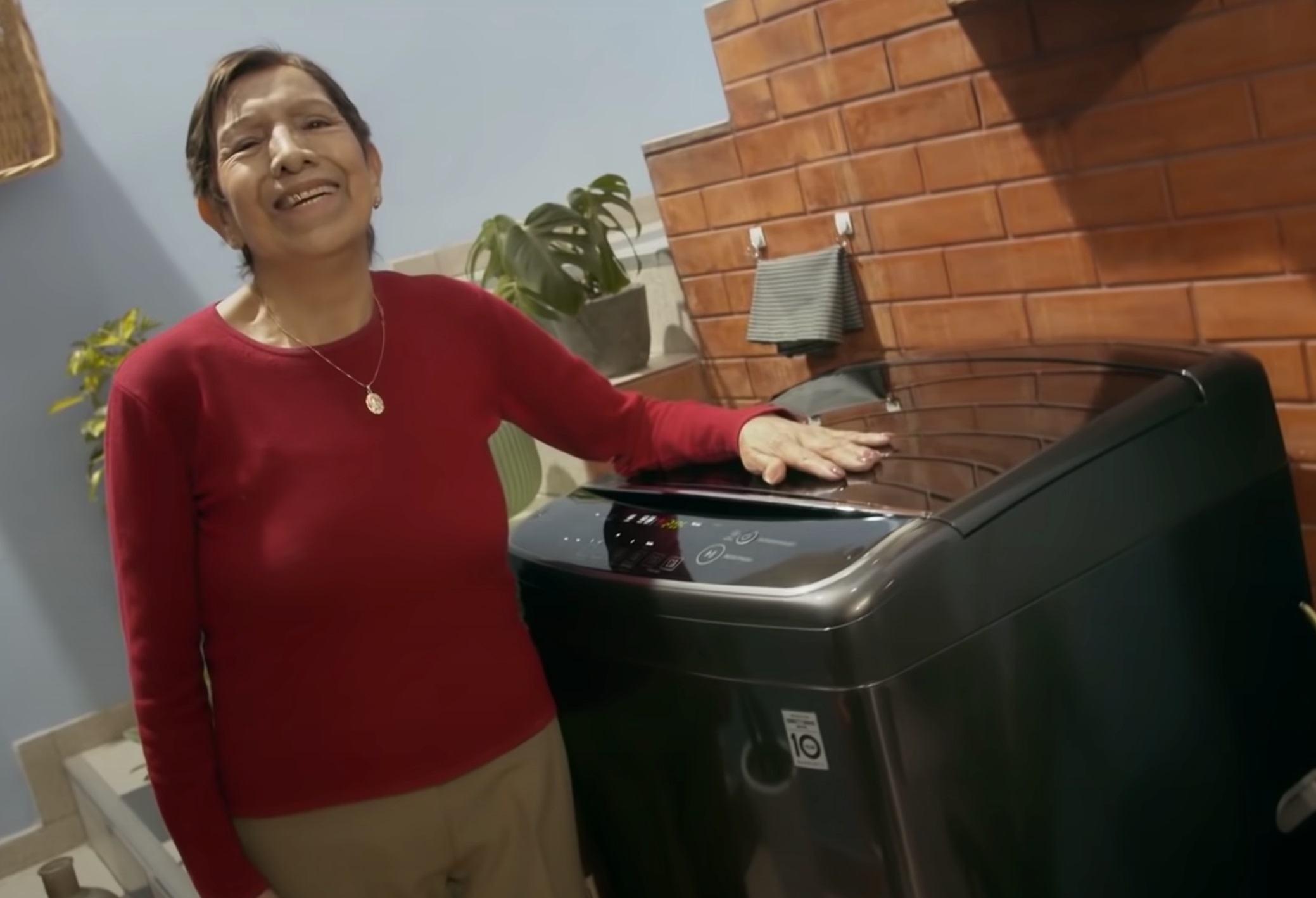 Carmen Mayhua posing with a brand new LG Top Load Washer given as a prize from winning the contest