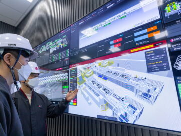 The workers at the Lighthouse Factory in Changwon are looking at the screen of virtual factory made by an Intelligent process system. (Horizontal)