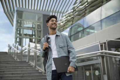 A man with a backpack is holding the LG gram laptop