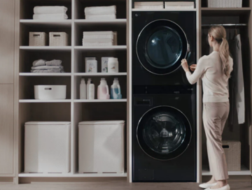 A woman opening up the door of LG Dryer which is the part of LG WashTower