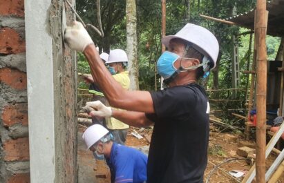 A worker working at the construction site to help upgrade housing for Muong households