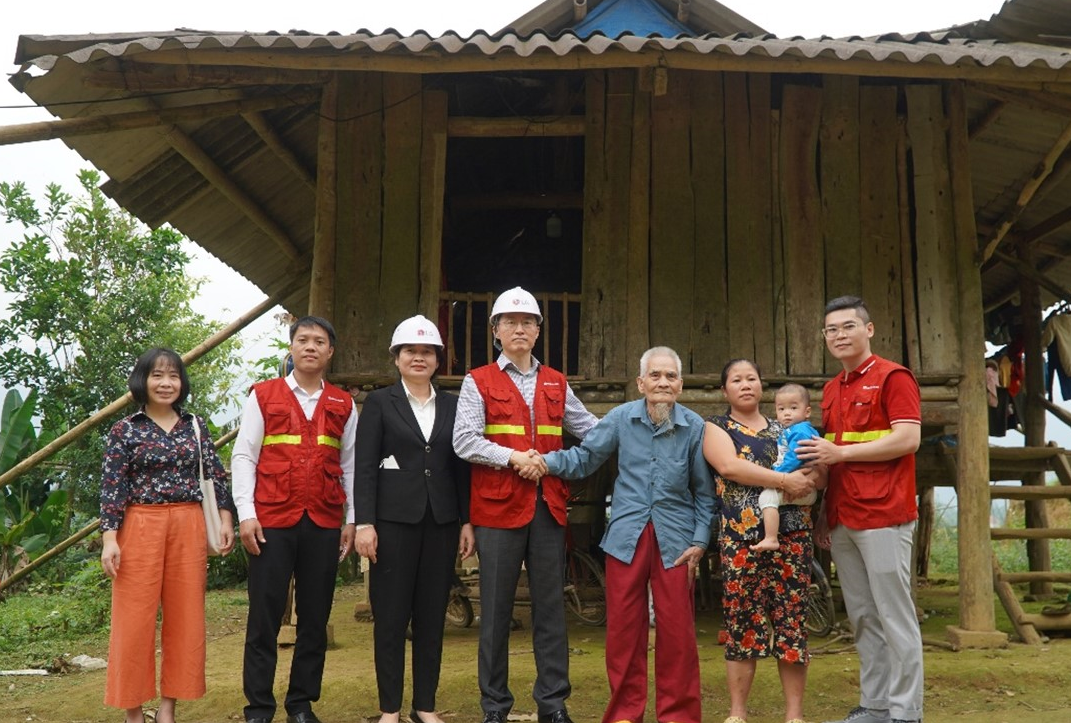 Representatives of LG Vietnam and Habitat for Humanity Vietnam are posing with Ms. Bui Thi Chien and her family infront of their house