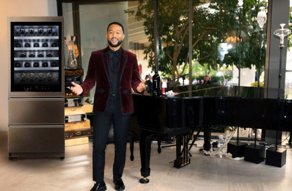 John Legend in suit posing in front of LG Wine Cellar