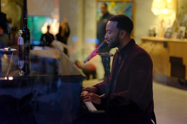 John Legend performing his songs with the piano at the event