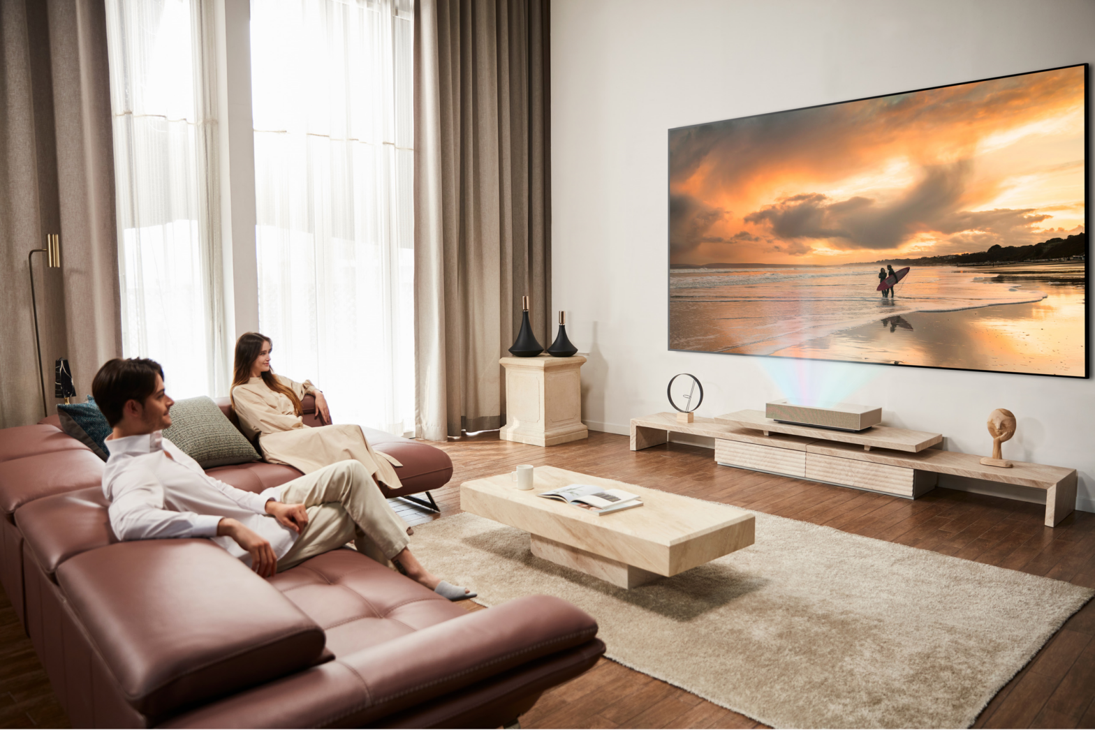 Use scenario of LG CineBeam – Two people are watching the projected screen in a living room