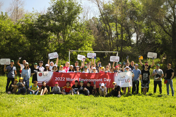 Staff of LG Kazakhstan and children from Almaty Regional Orphanage posing together for a photo after the planting activity