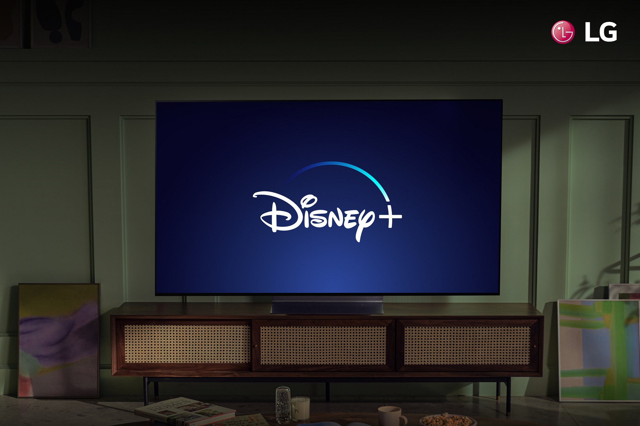 An LG TV in a living room displaying the Disney+ logo to celebrate the streaming service coming to more LG Smart TVs