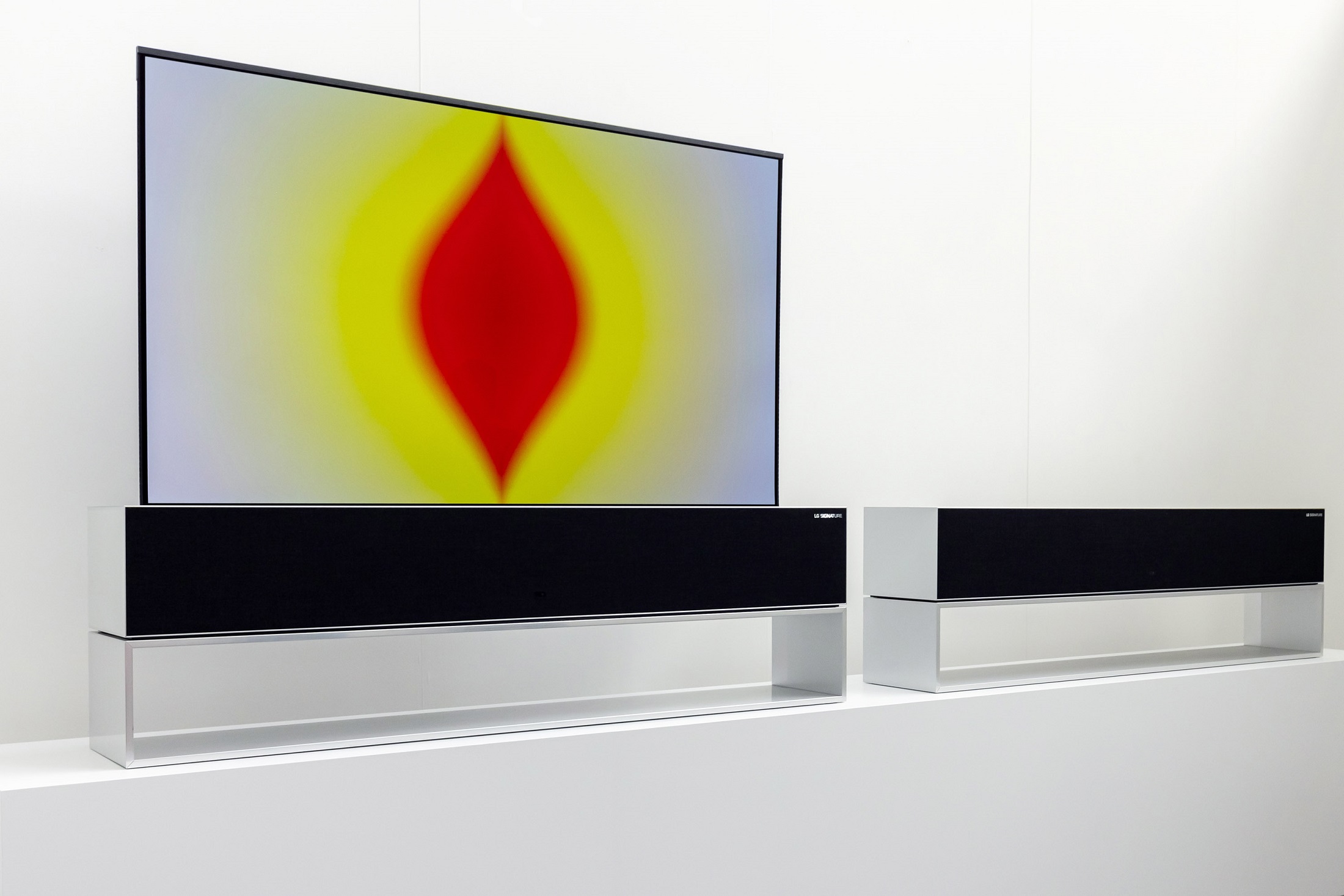 An LG SIGNATURE OLED R beautifully displaying Anish Kapoor’s colorful media art in its Full View mode, next to another with its screen hidden