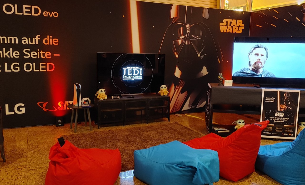 LG OLED booth decorated with bean bag chairs and LG OLED TVs displaying videos related to Star Wars