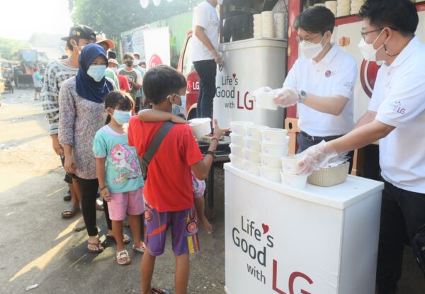 Lee Taijin, President of LG Electronics Indonesia, and Kris Lee, Product Marketing Director of Home Appliances LG Electronics Indonesia, serving food to people in Jakarta