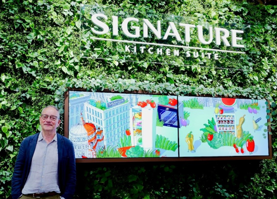 A visitor posing at the wall installed at Signature Kitchen Suite showroom