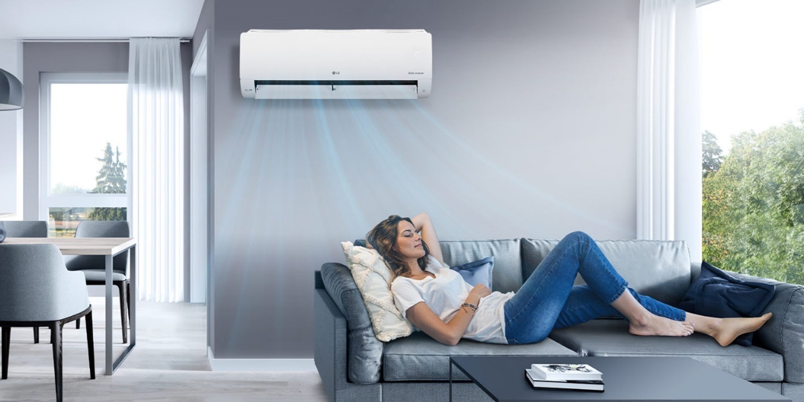 A woman lying on a couch under the LG air conditioner enjoying the cool air